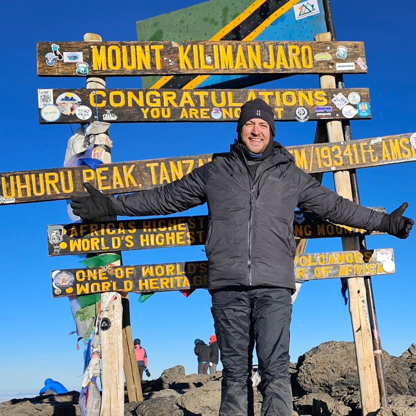 Tyler Woodall at the Uhuru Peak summit sign on Mount Kilimanjaro, Tanzania