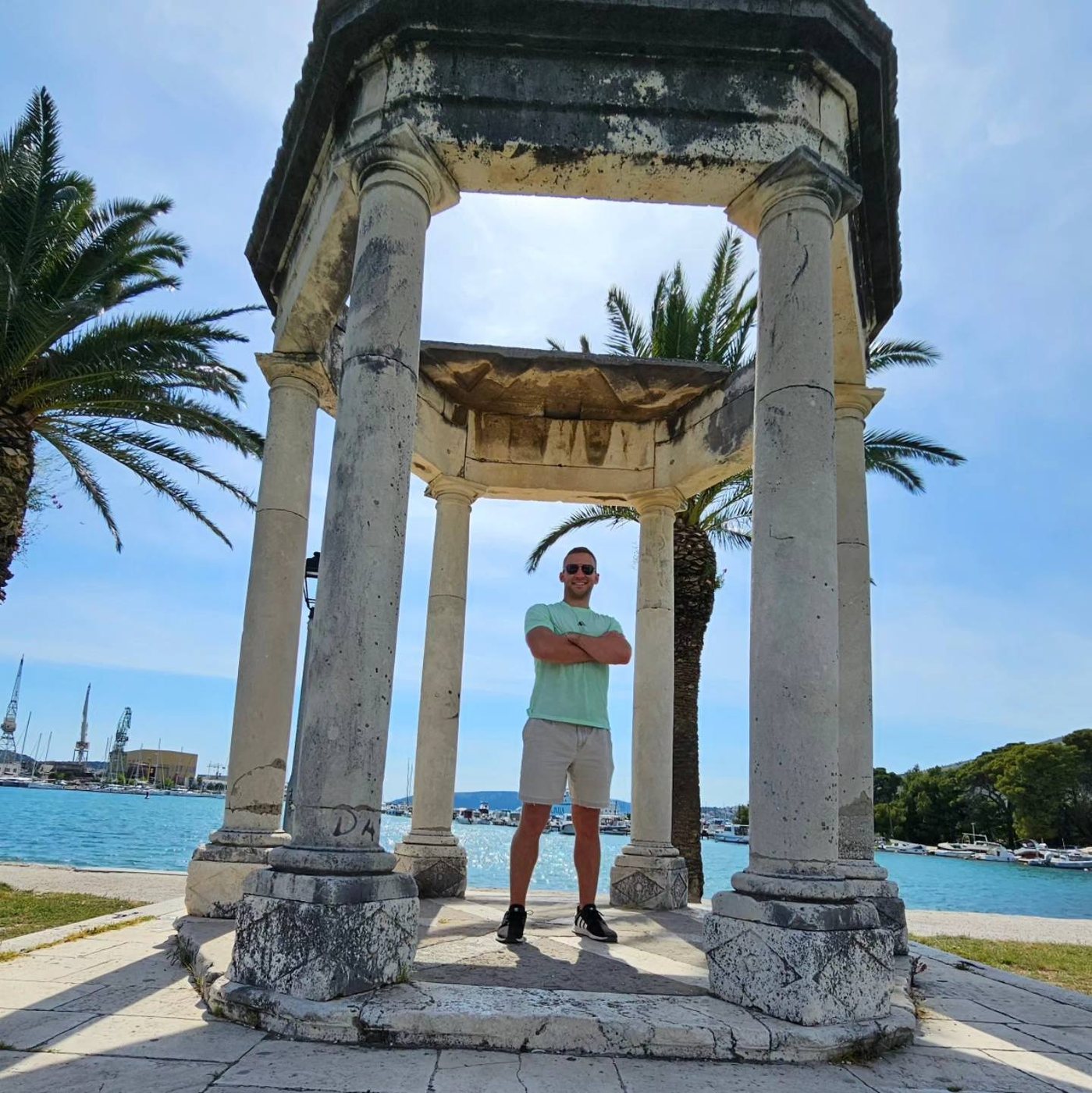 Tyler Woodall under a stone pavilion on the waterfront in Split, Croatia